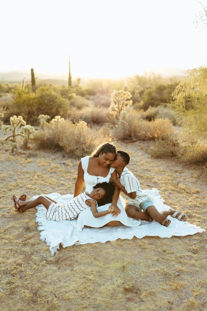 Family relaxing together on a blanket during sunset in the Arizona desert