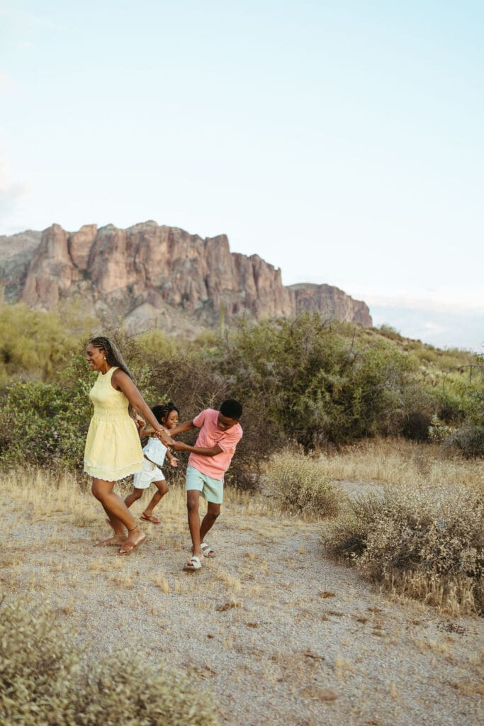 Mother and children playing together on a desert trail with mountain views in Arizona