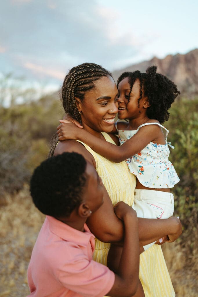 Mother hugging her children during a playful family photo session near Lost Dutchman State Park