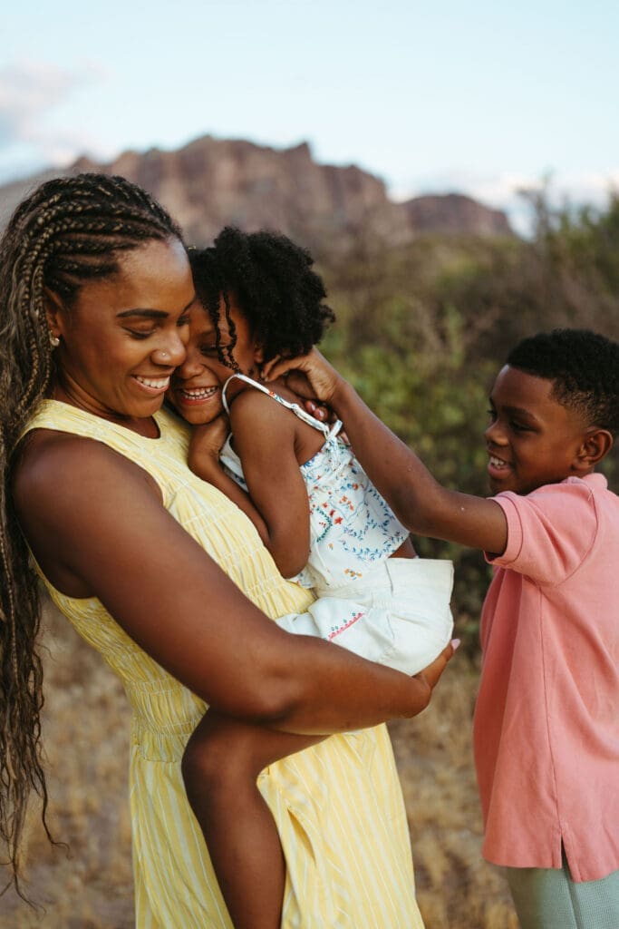 Mother cuddling her children during a family photography session near the Superstition Mountains in Arizona