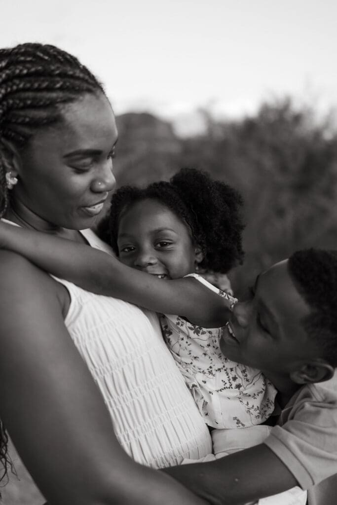 Black and white portrait of a mother embracing her children during a family photography session