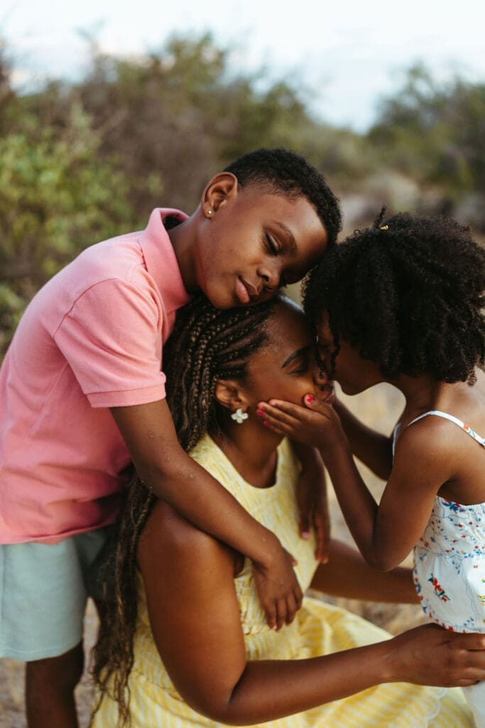 Brother and sister hugging their mother during an outdoor family photo session in Arizona