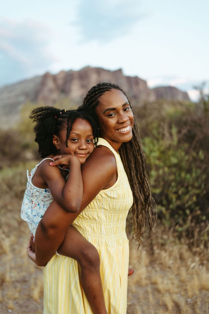 Mother carrying her daughter during a family photography session near the Superstition Mountains in Arizona