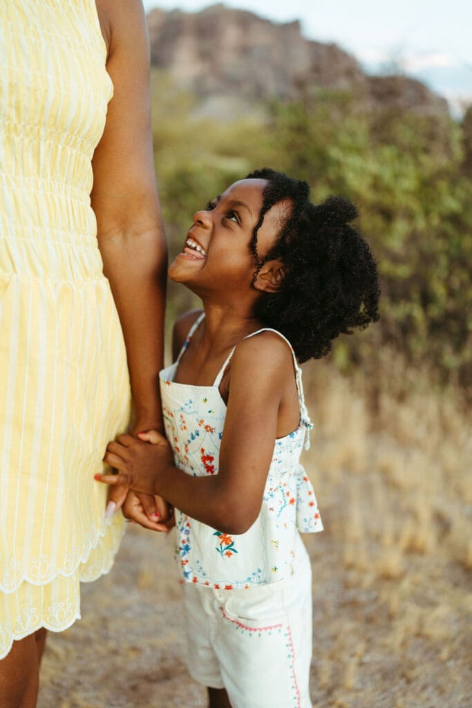 Playful portrait of a young girl laughing with her mother in the Arizona desert
