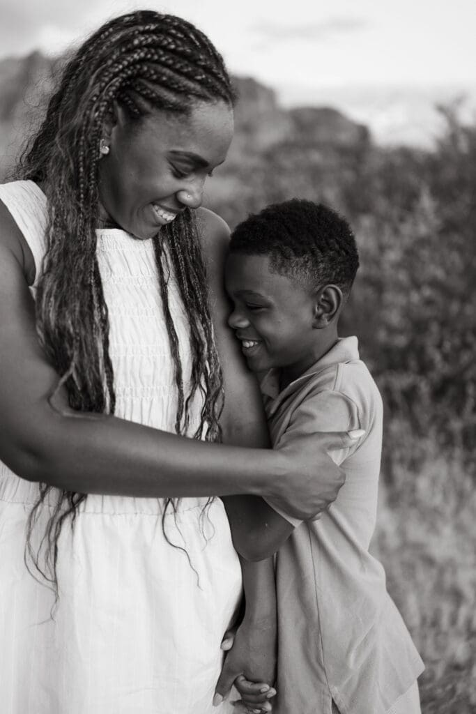 Black and white portrait of a mother and son sharing a candid moment during family photos