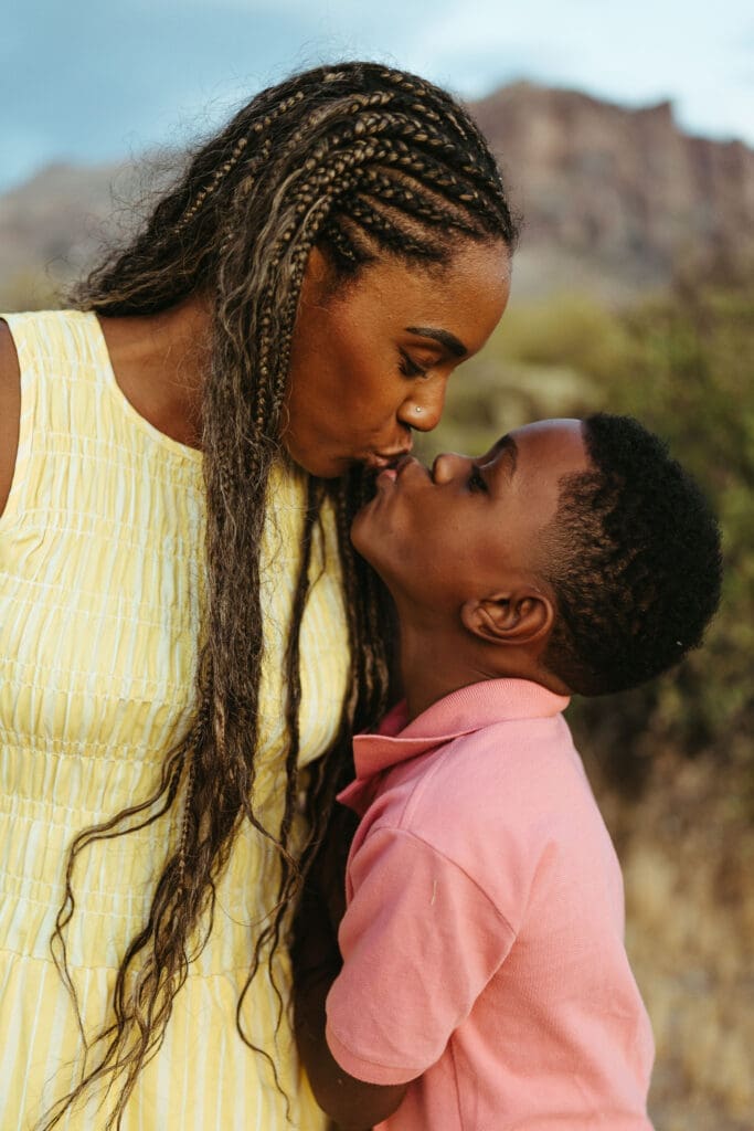 Mother kissing her son during a natural family photography session in Apache Junction