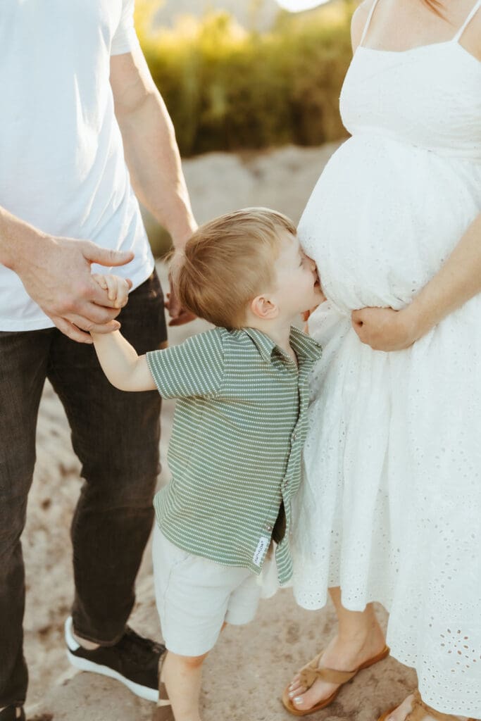 Toddler hugging his pregnant mom during a Salt River maternity photography session in Mesa, Arizona.