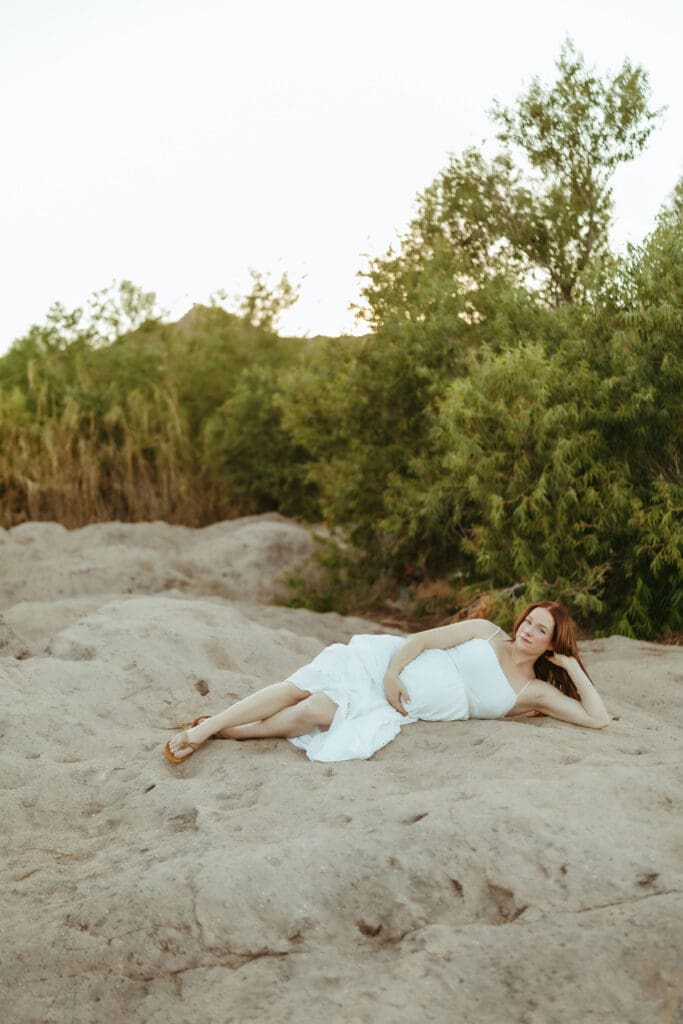 Father holding his smiling toddler during a family maternity session at the Salt River in Arizona.