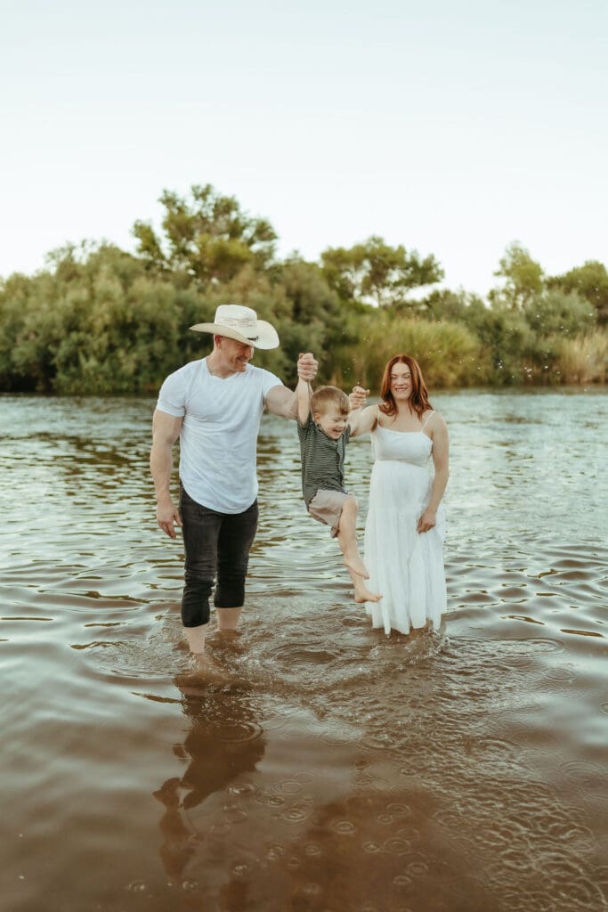Family walking through the Lower Salt River during a maternity photography session near Phoenix, Arizona.
