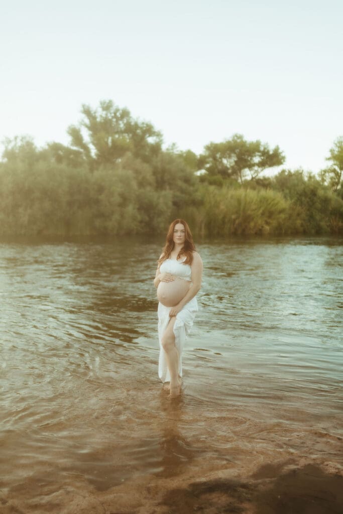Golden hour maternity portraits at the Lower Salt River in Mesa, Arizona with lush green scenery.