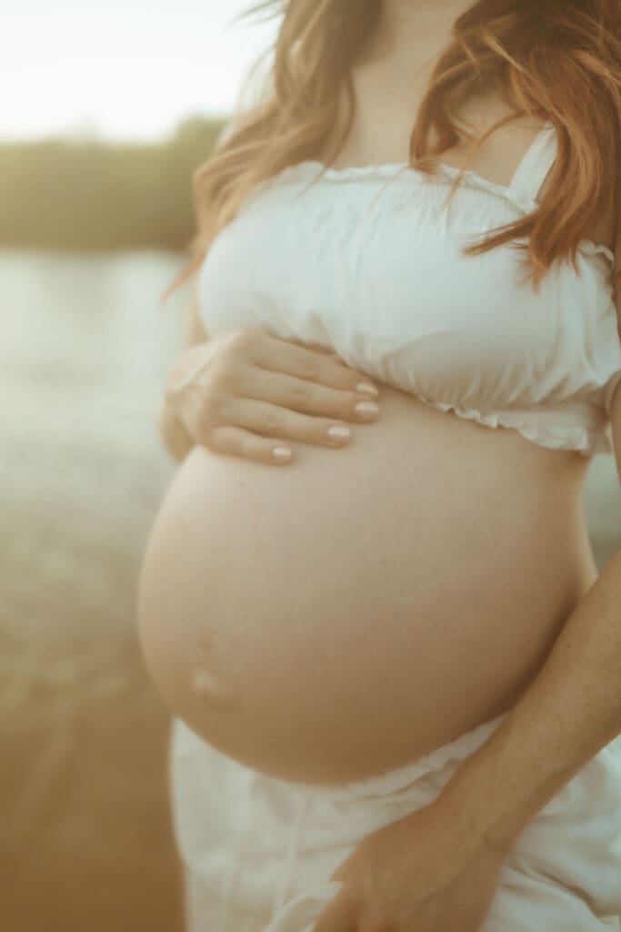 Close-up maternity portrait highlighting a growing baby bump during a Salt River maternity session in Arizona.