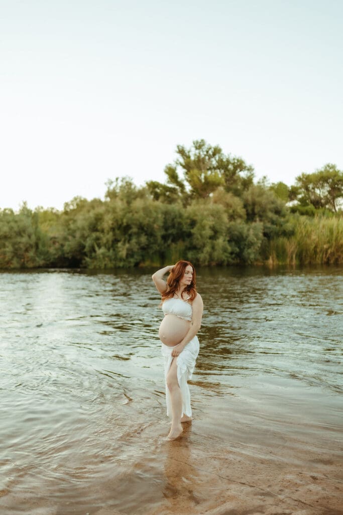 Pregnant mother walking through the Salt River during a natural outdoor maternity photography session in Mesa, Arizona.