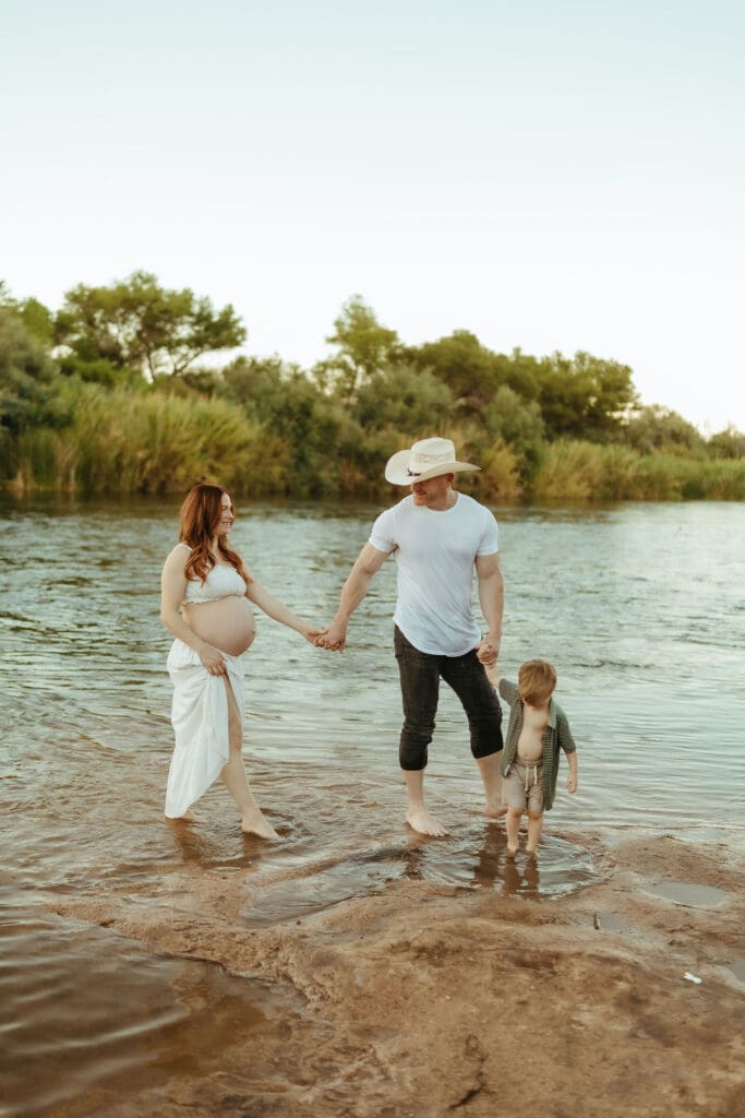 Pregnant mother walking through the Salt River during a natural outdoor maternity photography session in Mesa, Arizona.