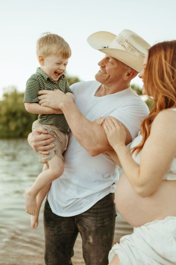 Joyful family maternity photos with parents laughing together at the Lower Salt River near Phoenix, Arizona.