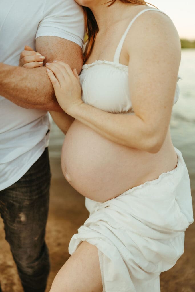 Close-up maternity portrait highlighting a growing baby bump during a Salt River maternity session in Mesa, Arizona.