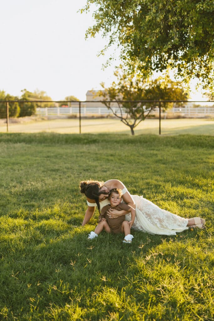 Mother cuddling her toddler during a joyful outdoor family maternity session in Queen Creek, Arizona.