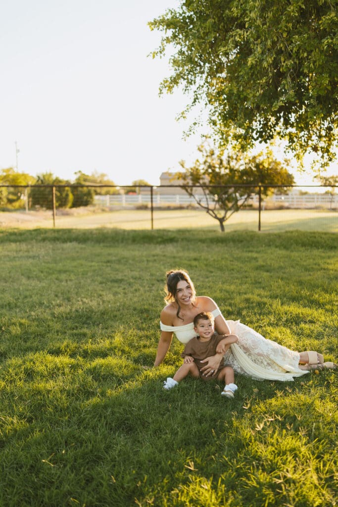 Mother cuddling her toddler during a joyful outdoor family maternity session in Queen Creek, Arizona.