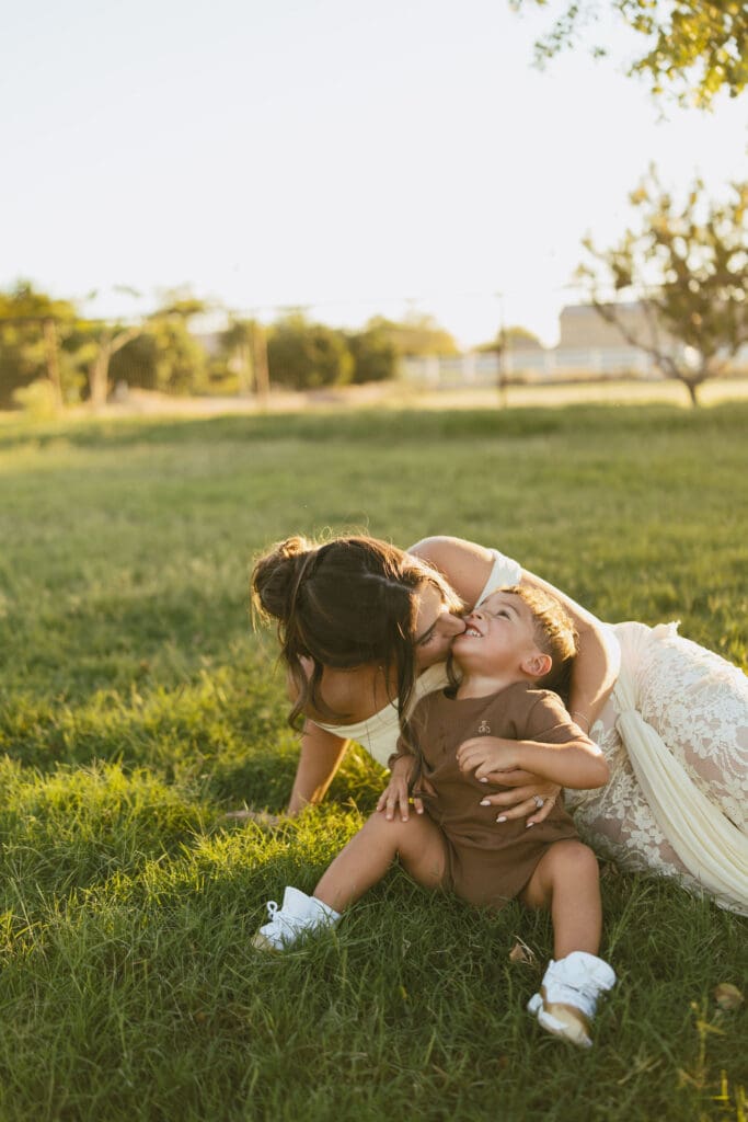 Mother cuddling her toddler during a joyful family maternity session in Gilbert, Arizona.