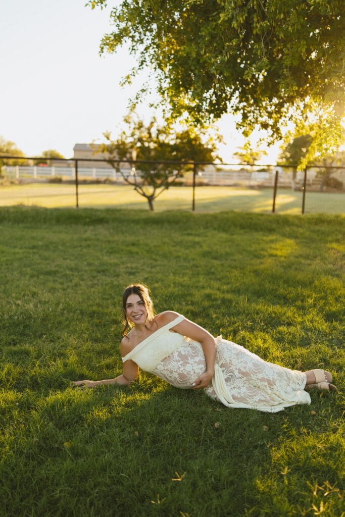 Pregnant mother relaxing in the grass during a golden hour maternity session at Patch of Paradise AZ.
