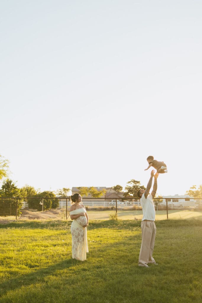 Family of three celebrating a new baby during an outdoor maternity session in Gilbert, Arizona.