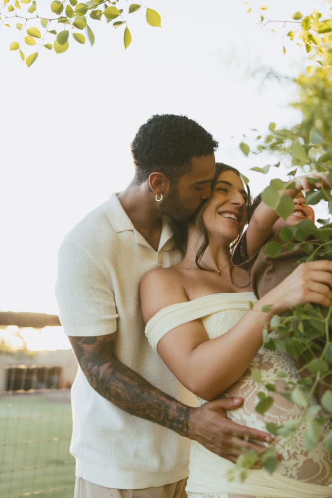 Father hugging his pregnant wife and toddler during a sunset maternity session at Patch of Paradise AZ.