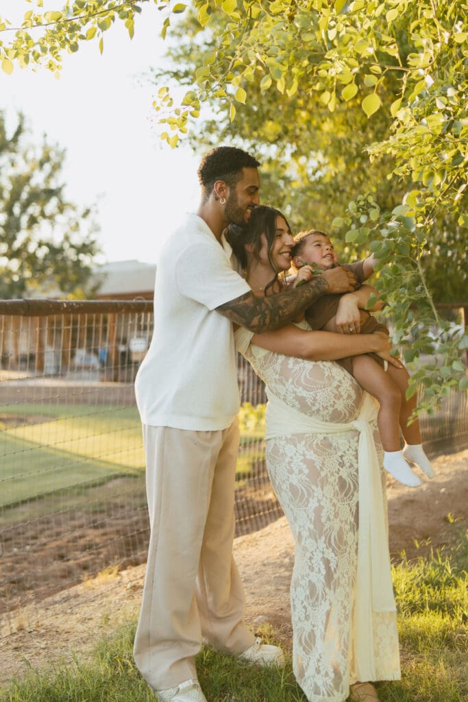 Pregnant mother standing on the front porch during a golden hour maternity session in Gilbert, Arizona.
