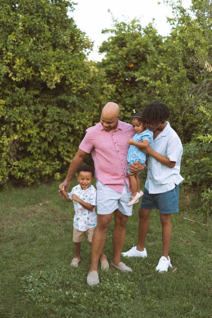 Family of four sharing a candid moment during a family photography session at Hagen Farms in Queen Creek, Arizona.