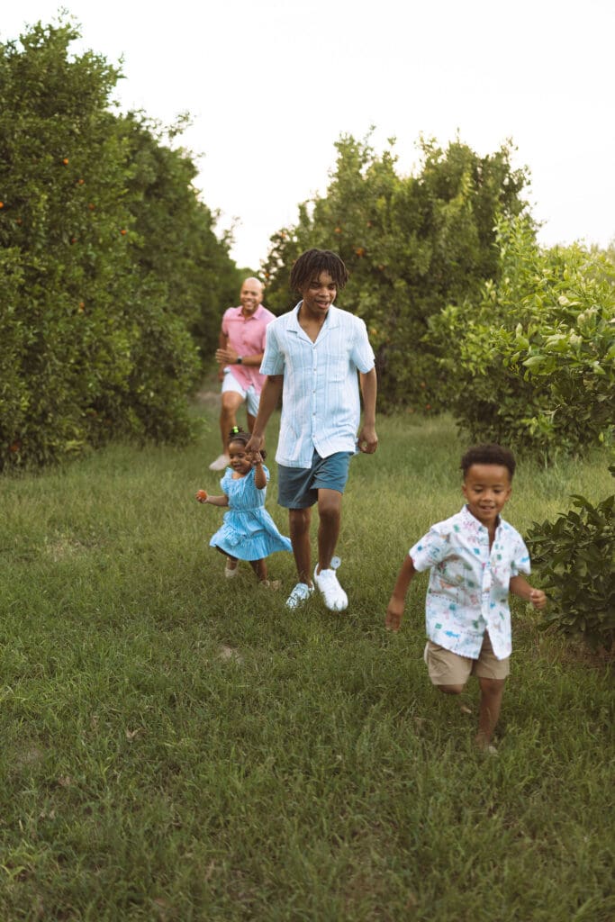 Family walking together through Hagen Farms during a relaxed outdoor family session in Queen Creek.