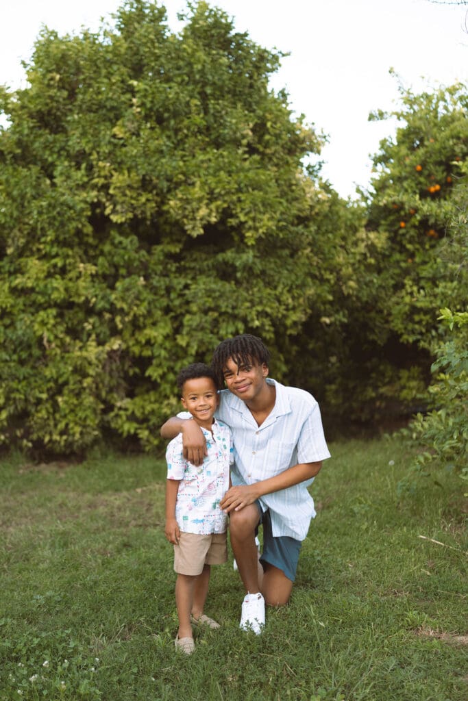 Older brother hugging his younger brother during a family photo session at Hagen Farms in Queen Creek.