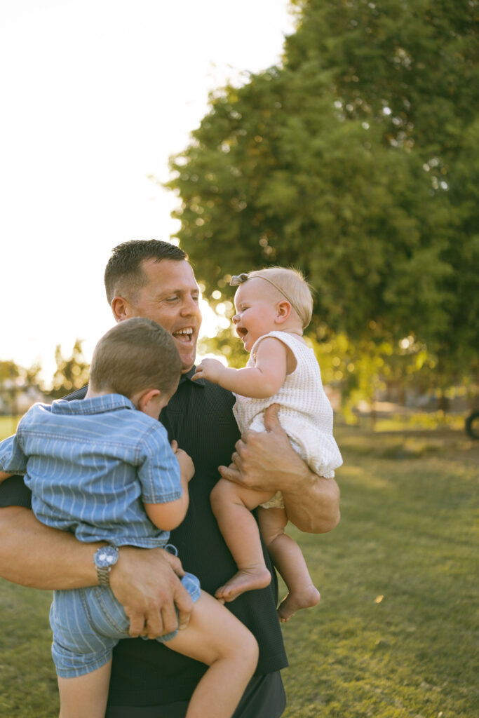 Parents helping their toddler gently pet a friendly duck during a candid Gilbert family photography session.