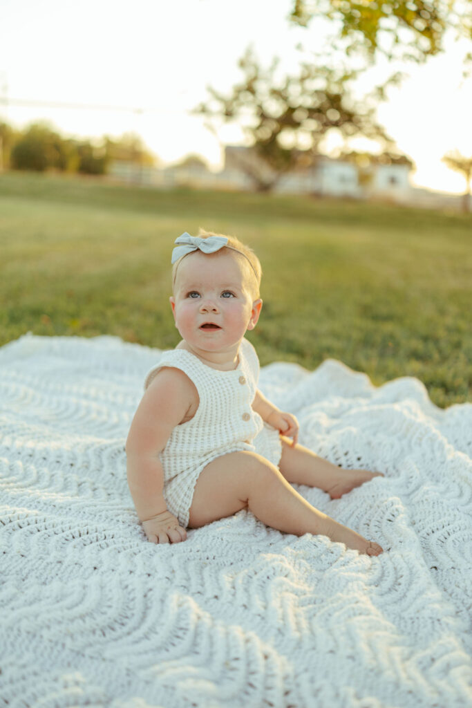 Toddler sitting on a cozy blanket during an outdoor lifestyle family session in Gilbert, Arizona.
