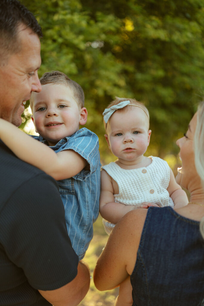 Parents holding their son and daughter during a natural outdoor family session in Gilbert, Arizona.