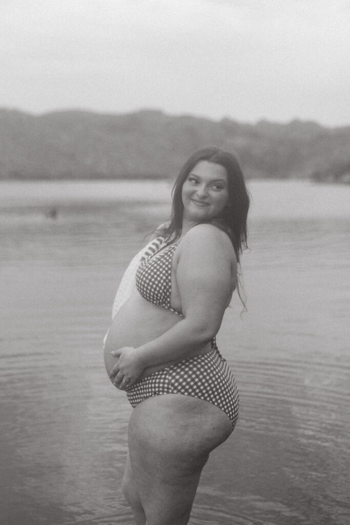 Artistic black and white portrait of a smiling expecting mother during a maternity session at Butcher Jones Beach in Mesa.