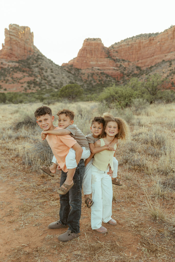 Mother holding her young son while siblings gather nearby during a relaxed Sedona family photography session.