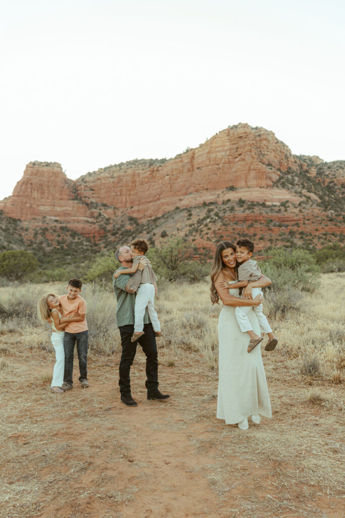 Parents sharing a quiet moment with their children during a sunset family session in Sedona's beautiful desert landscape.