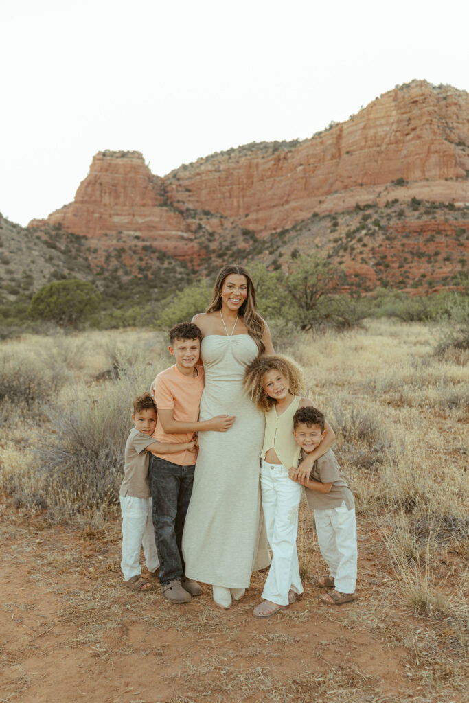 Sedona family photographer capturing a timeless portrait of parents and four children with stunning red rock scenery behind them.