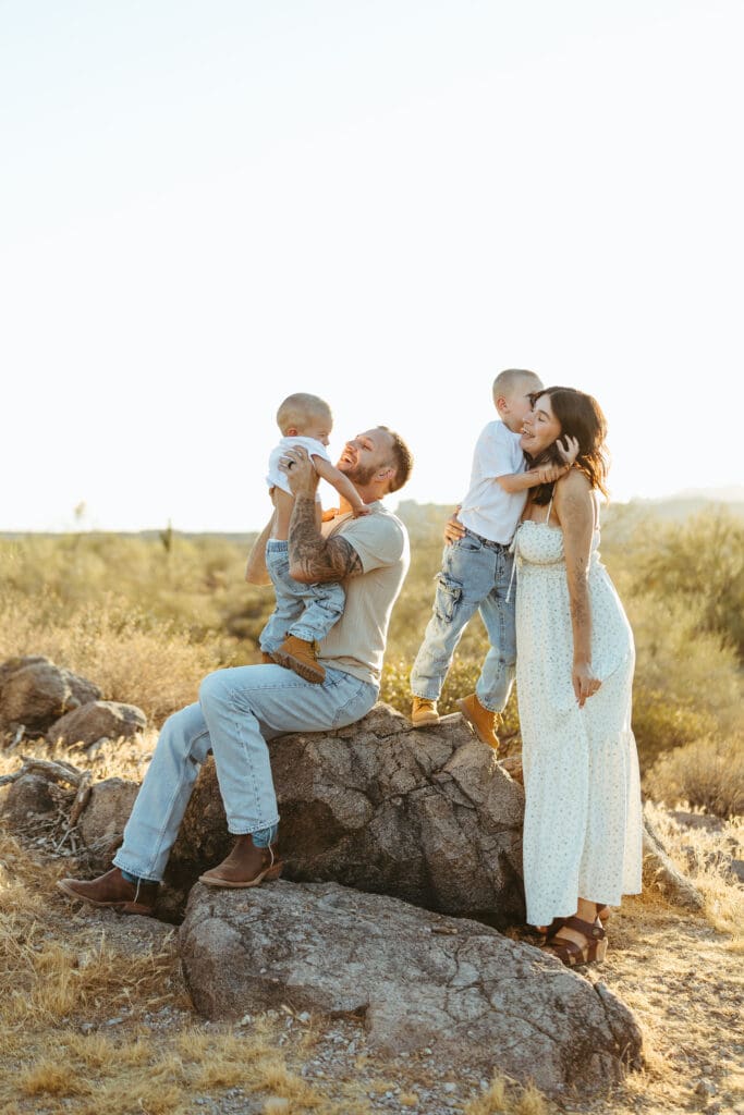 Family of four celebrating a new baby with a pregnancy announcement session in Scottsdale, Arizona