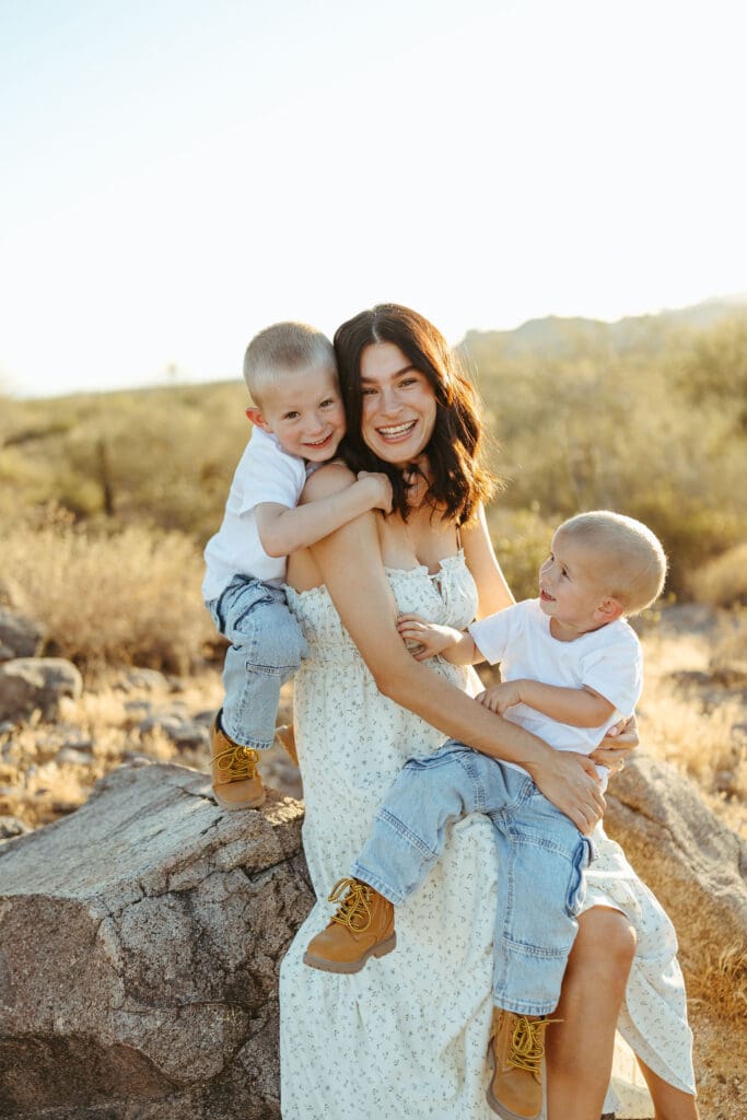 Expecting mother holding her two sons during a maternity and pregnancy announcement session near the Superstition Mountains