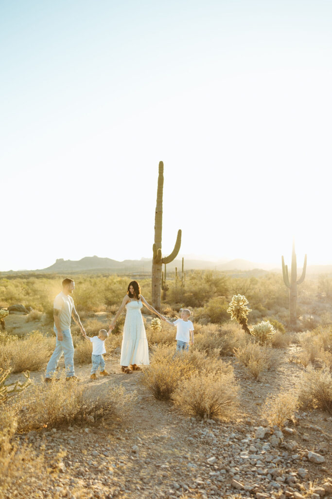 Family walking through the Arizona desert during a Superstition Mountains maternity session