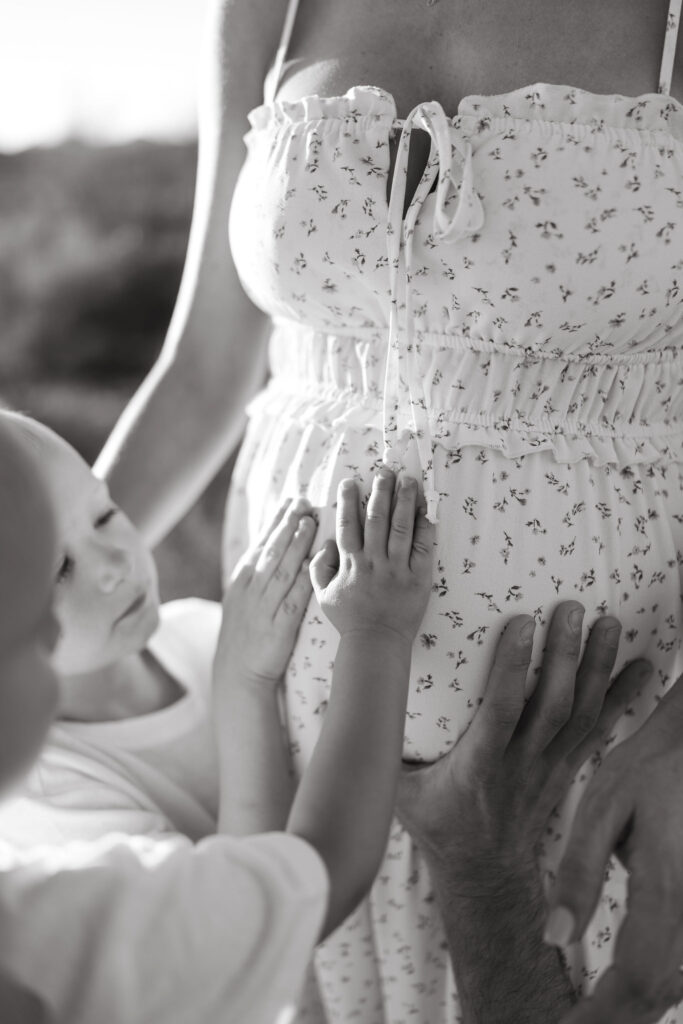 Big brothers touching their mother's baby bump during a pregnancy announcement session in Scottsdale