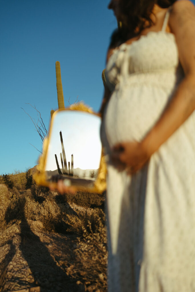 Creative pregnancy announcement photo with Arizona desert reflection and saguaro cactus near Scottsdale