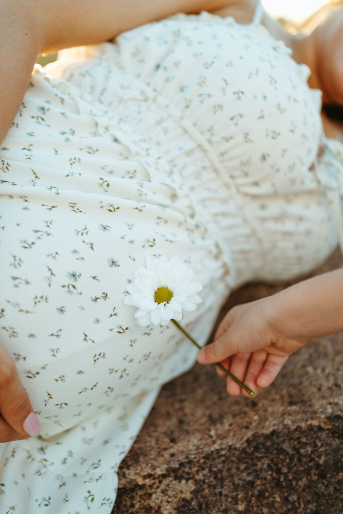 Close-up maternity detail photo with daisy on baby bump during a Scottsdale maternity session