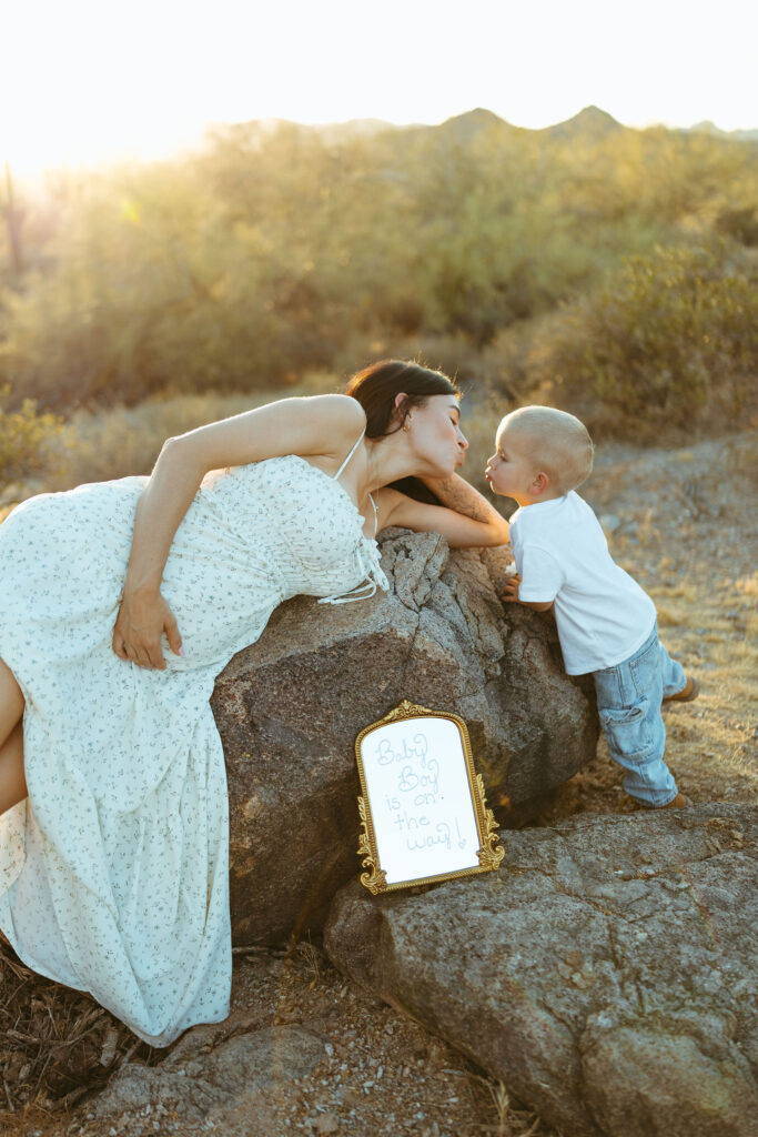 Pregnancy announcement sign with mother and son during a Superstition Mountains maternity session