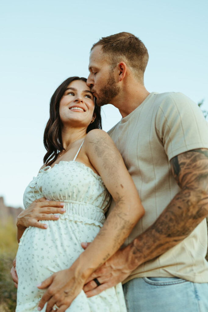 Couple celebrating pregnancy with mountain views during a Scottsdale desert maternity session