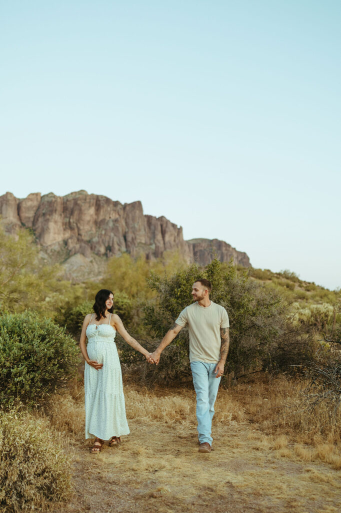 Expecting couple walking through the Superstition Mountains during a Scottsdale maternity photography session