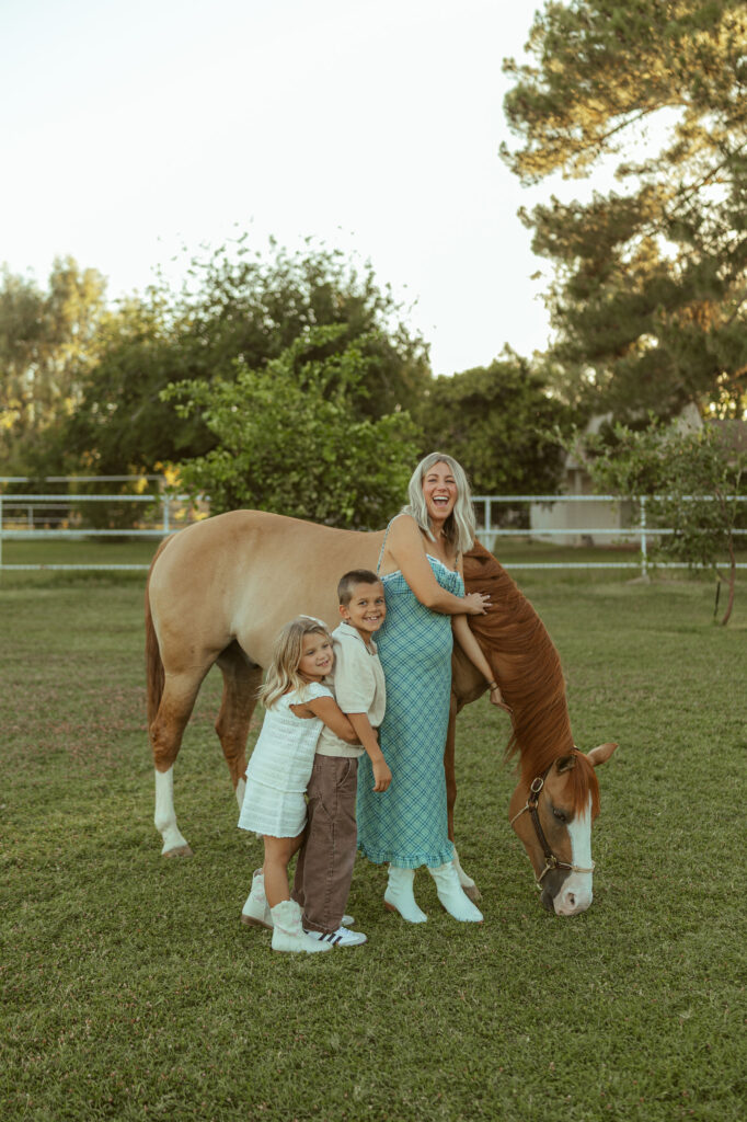 Gilbert maternity photographer documenting a pregnancy announcement with horses featuring siblings and their expecting mom during an outdoor family session.