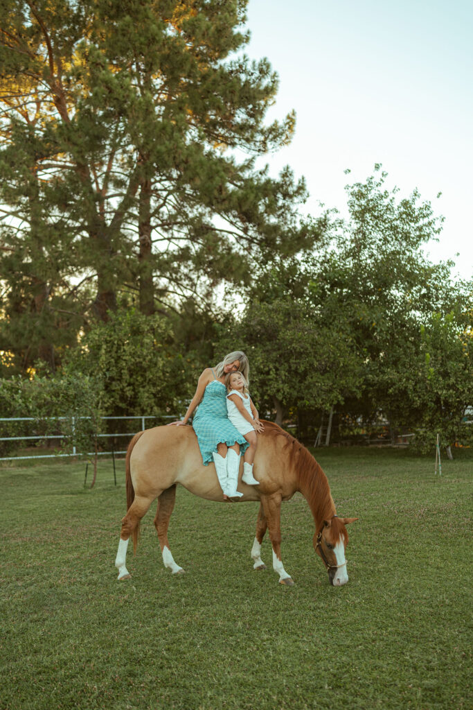 Western maternity photography featuring an expecting mom riding her family horse during a peaceful pregnancy announcement session in Gilbert.