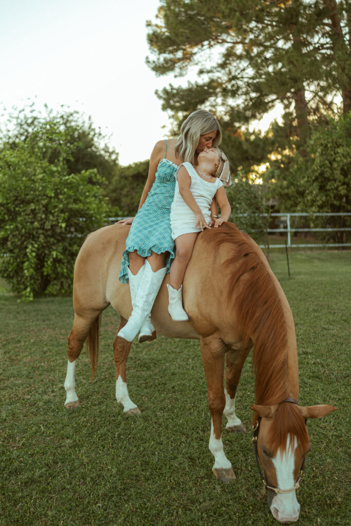 Lifestyle pregnancy announcement featuring an expecting family cuddling together beside their horse at Floyd Family Farms in Gilbert.