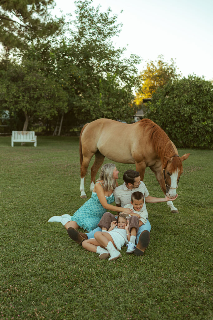 Creative sibling pregnancy announcement showing a big brother and big sister sitting together on their horse with ultrasound photos in Gilbert, Arizona.