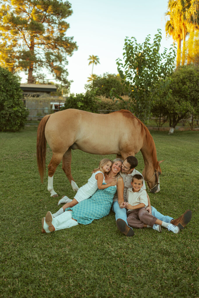 Creative sibling pregnancy announcement showing a big brother and big sister sitting together on their horse with ultrasound photos in Gilbert, Arizona.